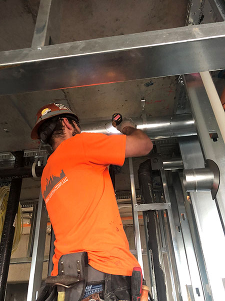 Residential sheet metal worker installing duct work 
